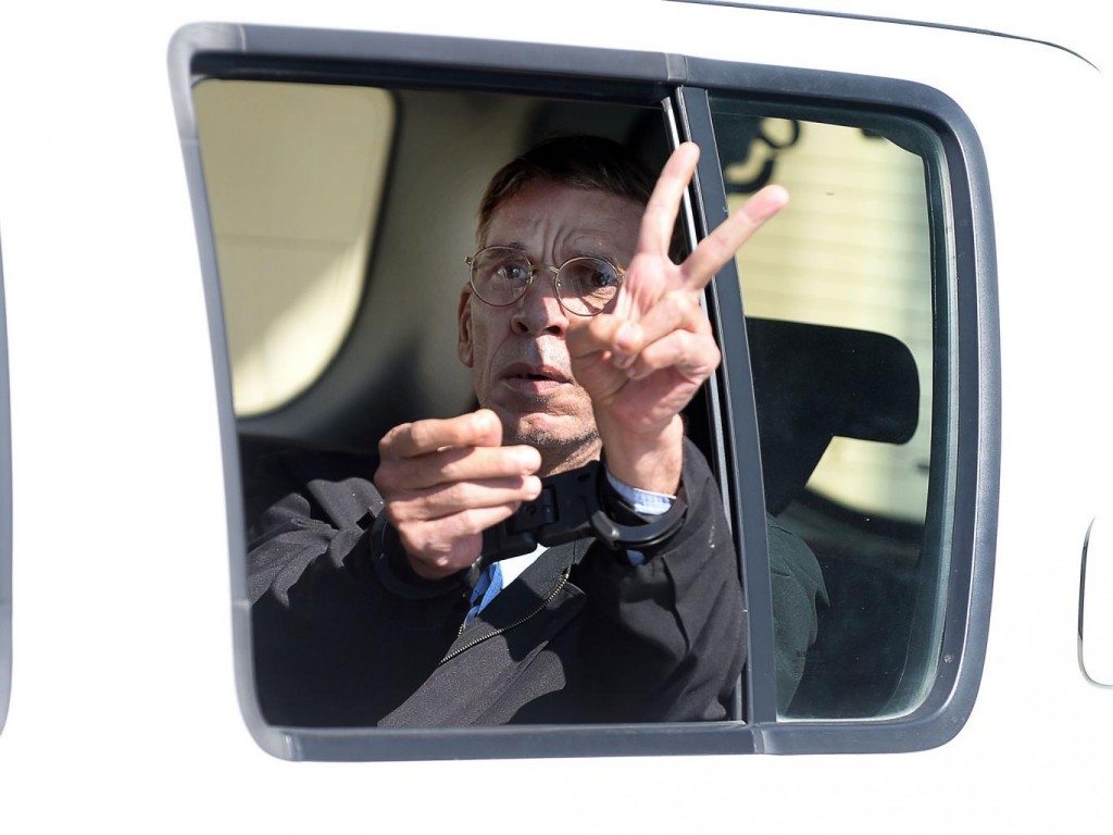 Seif Eldin Mustafa makes the "V" (victory) sign as he leaves the court in Larnaca in a police car on March 30, 2016 (PHOTO: AFP/Getty Images) 